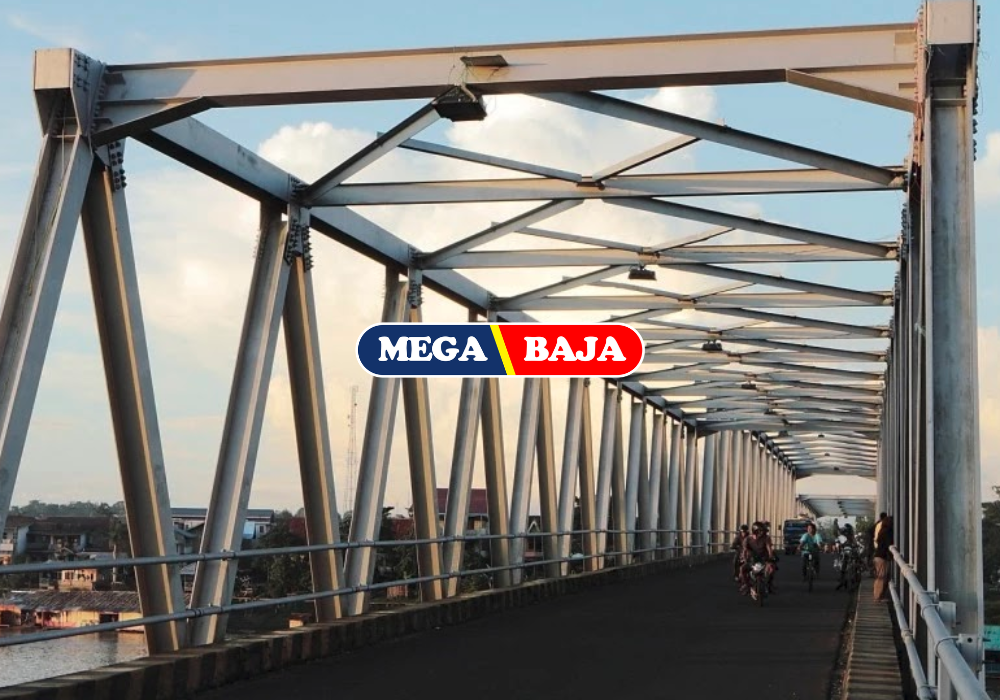 Jembatan baja kokoh dengan struktur rangka besi yang melintasi sungai, digunakan oleh kendaraan dan pejalan kaki saat senja.